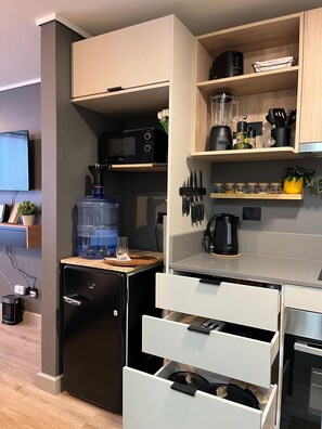 Een minikoelkast, een microgolfoven, een oven, een kookplaat