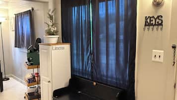 Una habitación con un mueble de almacenamiento negro, un armario con la etiqueta 'Lions', una planta y un letrero en la pared que dice 'KEYS'.