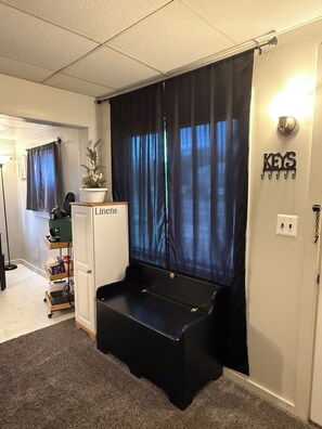 A room with a black storage unit, a cabinet labeled 'Lions,' a plant, and a wall-mounted sign reading 'KEYS.'