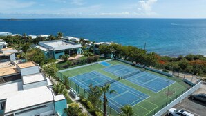 A tennis court with a view of the ocean. - New central located 2BR/3BD/2BA condo gated community with 2 pools & pickleball (St Thomas)