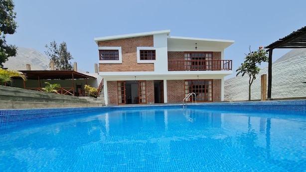 Una casa moderna de dos pisos con piscina delantera.