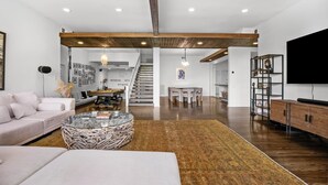 A spacious living area with a sofa, coffee table, and a staircase leading to a dining area. - Sherman Oaks Oasis with Views and Pool Table (Los Angeles)
