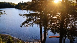 A calm lake with a wooden dock and a canoe. - Beautiful Lakefront Inn Suites (Parry Sound)