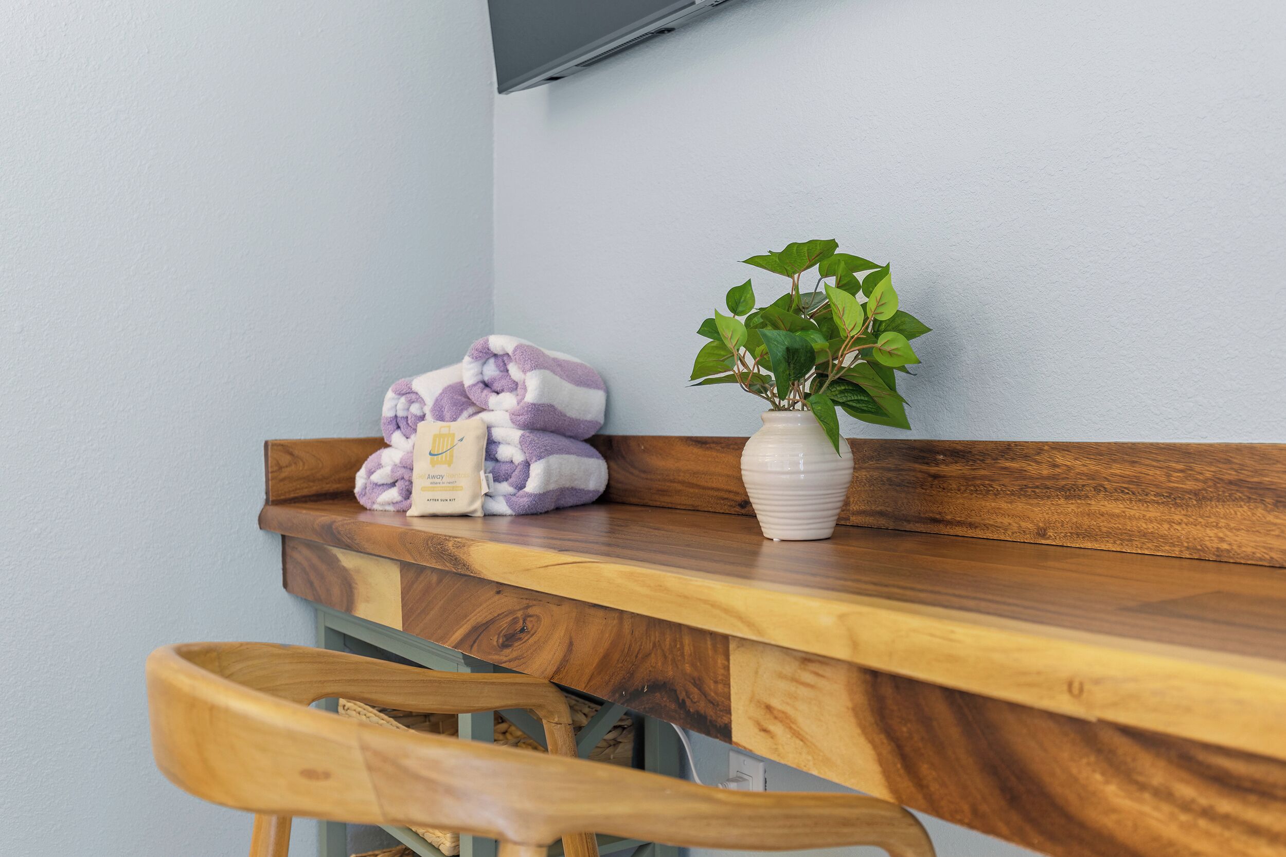 A wooden desk with a plant and towels.