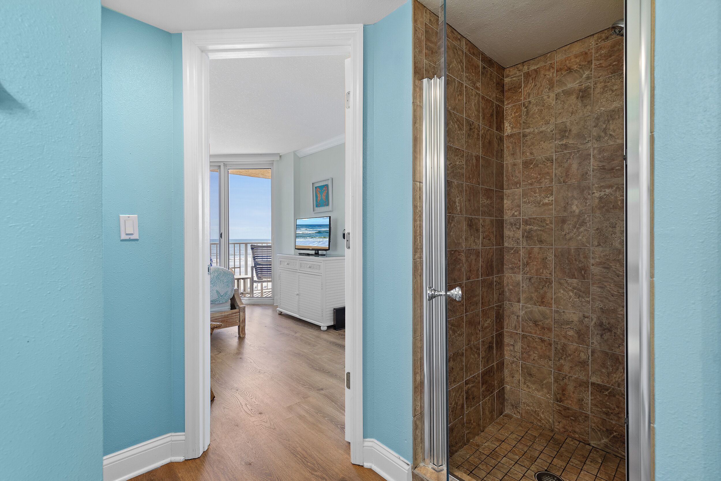 Un baño con ducha, tocador y vistas al exterior.
