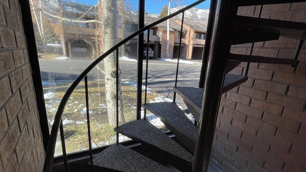 A spiral staircase with metal railings leading to a second-floor landing.