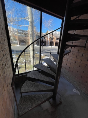 A spiral staircase with metal railings leading to a second-floor landing.