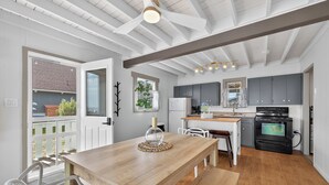 Una cocina moderna con armarios grises, una mesa de comedor de madera y un horno negro.