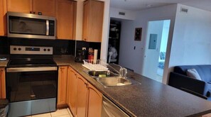 Eine Küche mit Holzausstattung, einer Mikrowelle, einem Backofen und einem Spülbecken.
