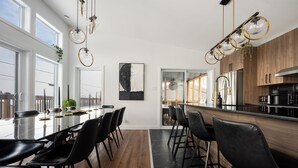 Una cocina moderna con armarios de madera, un refrigerador de acero inoxidable y una encimera negra.