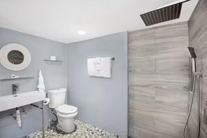 Ein modernes Badezimmer mit Toilette, Waschbecken und Dusche.