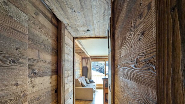 Un intérieur en bois avec un canapé et une fenêtre.
