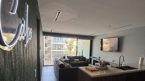 Cuina moderna amb una illa central, forn integrat i un gran finestral que aporta llum natural.
