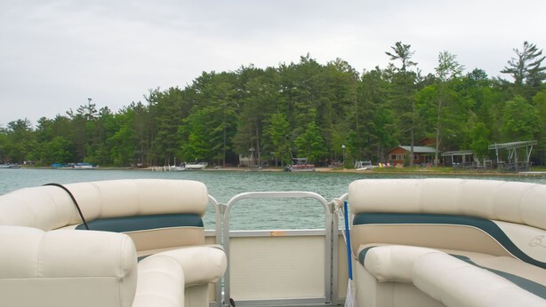 The interior of a boat with two cushioned seats and a metal railing. - Loon Lodge on Bear Lake (Bear Lake)