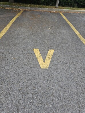 Uma área de estacionamento com uma marcação em amarelo em formato de 'V' no chão.