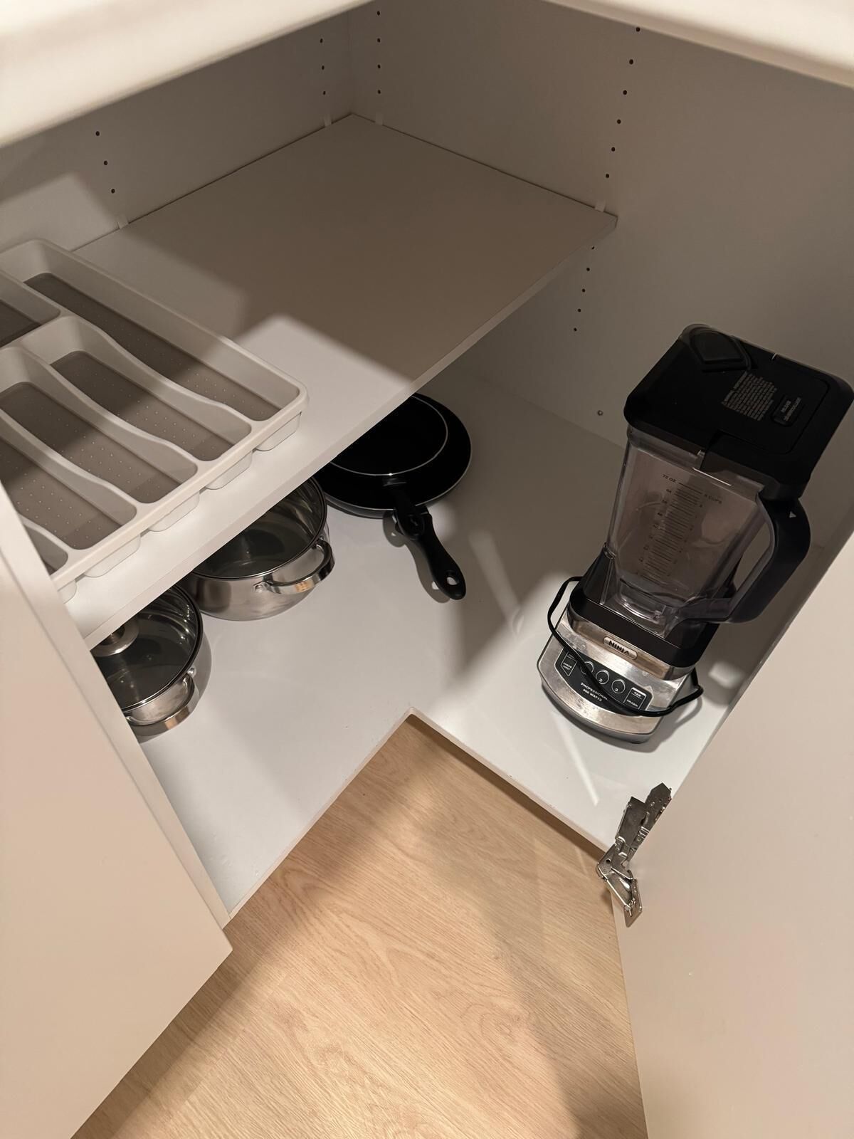 A kitchen with a built-in coffee maker, a kettle, and a pan.