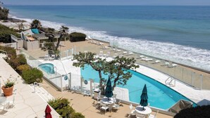 A pool area with a view of the ocean, lounge chairs, and a small pool. - Oceanfront Gem w/ Balcony, Pool, Hot Tub & Carbon Beach Access Bluewater Haven by Avantstay (Malibu)