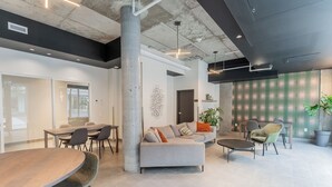 Un interior moderno con zona de comedor, asientos y una columna grande.