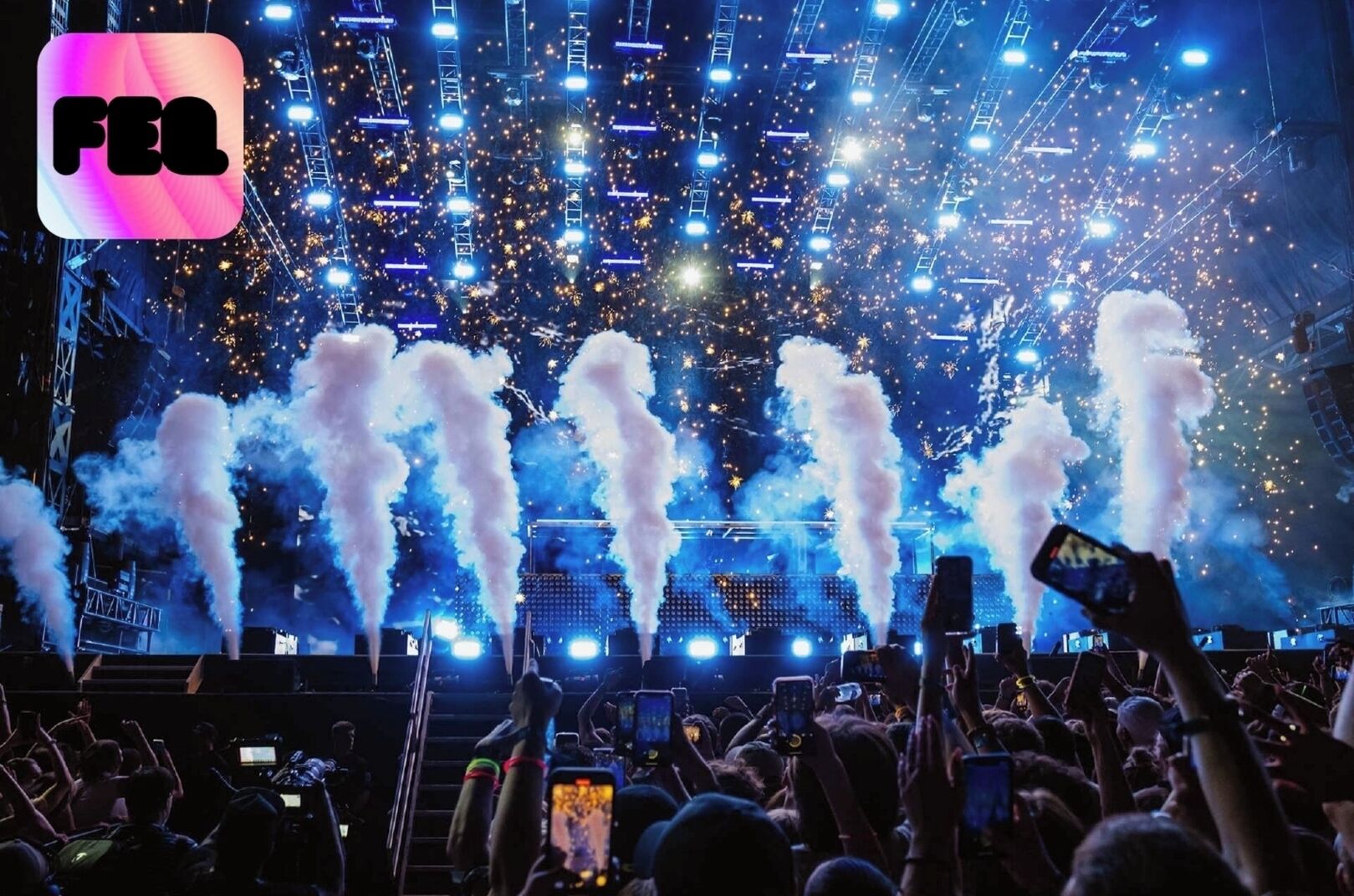 A concert with pyrotechnics and a crowd of people holding up phones.