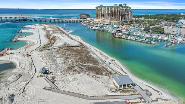 A coastal area with a marina, a large hotel, and a pier extending into the water. - Palms Resort #2307 JR 2BR (Destin)