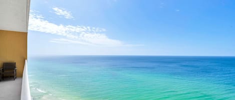 A balcony with a view of the ocean and beach.