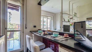Une cuisine moderne dotée d’un grand îlot central, de tabourets de bar et offrant une vue sur l’extérieur.