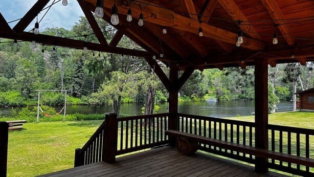Une terrasse en bois offrant une vue sur un lac et la végétation environnante.