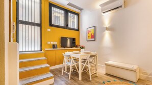 A compact living space with a kitchen area, a dining table, and a sofa. - Garibaldi's Gem - La Vista Apartments (Milano)