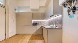 A modern kitchen with a microwave, sink, and stainless steel appliances. - New NoLo - La Vista Apartments (Milan)