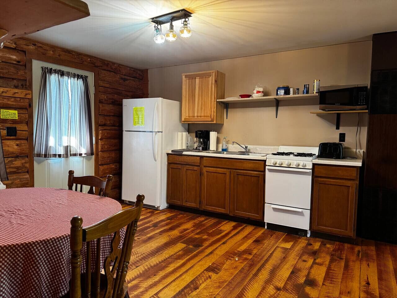 A compact kitchen with wooden cabinets, a white stove, and a refrigerator.