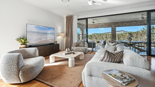 A modern living room with a large TV, comfortable seating, and a view of the outdoors. - Holiday Crescent – Spacious, stylish retreat with pool, perfect (Berry)