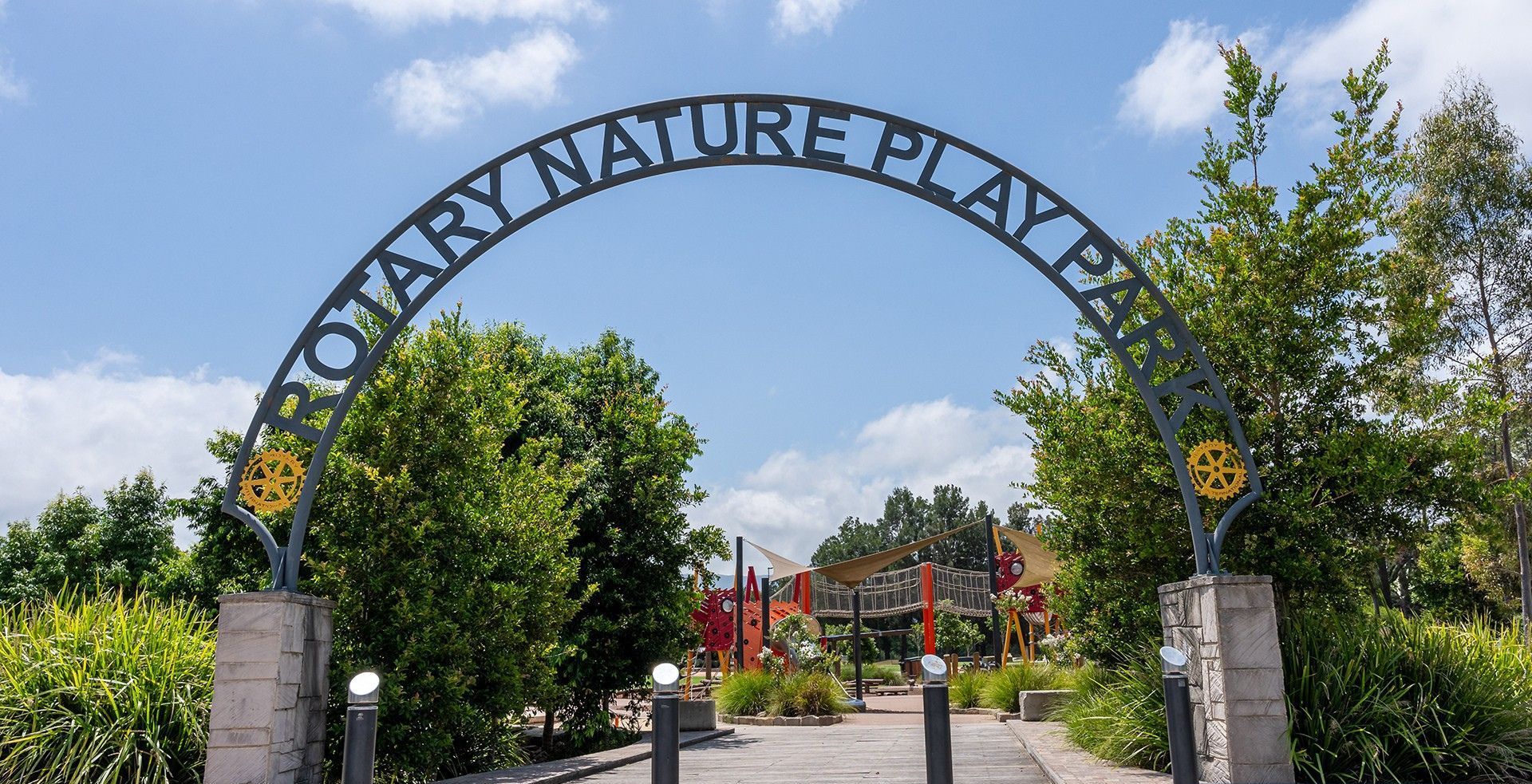 Een boog met de tekst 'NATURE PLAY PARK' en decoratieve details.