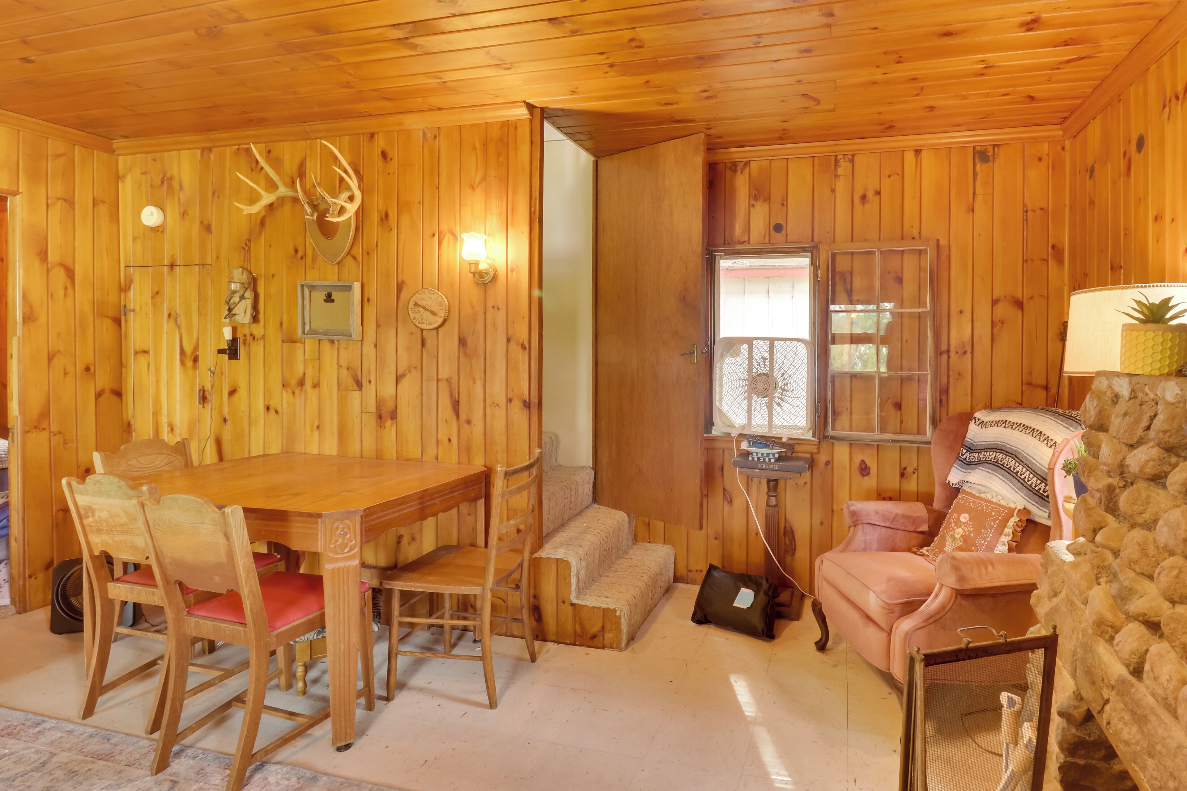 Un interior de madera con una mesa de comedor, sillas, un sofá y una chimenea.