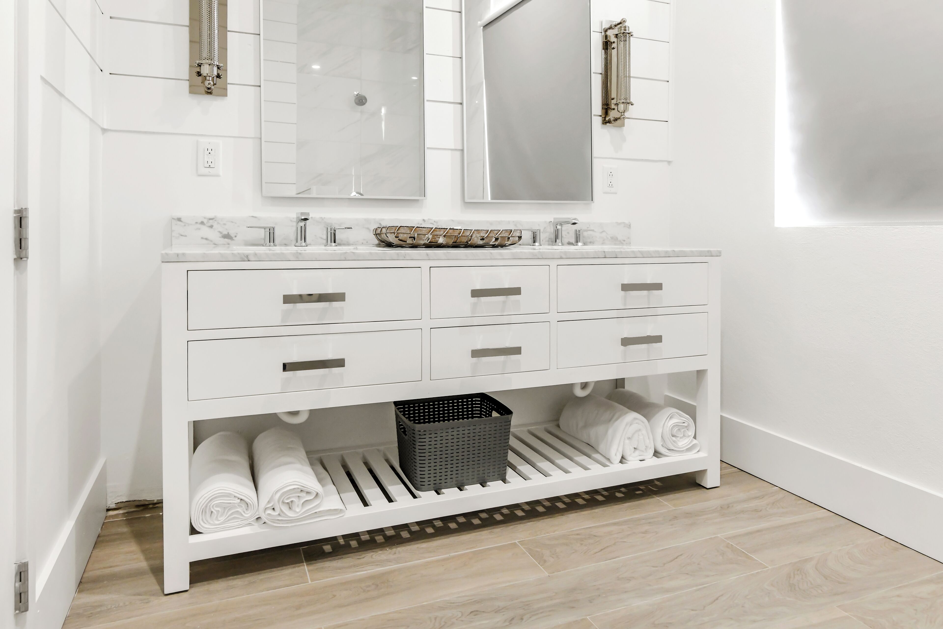 A white vanity with a marble countertop, two mirrors, and six drawers.