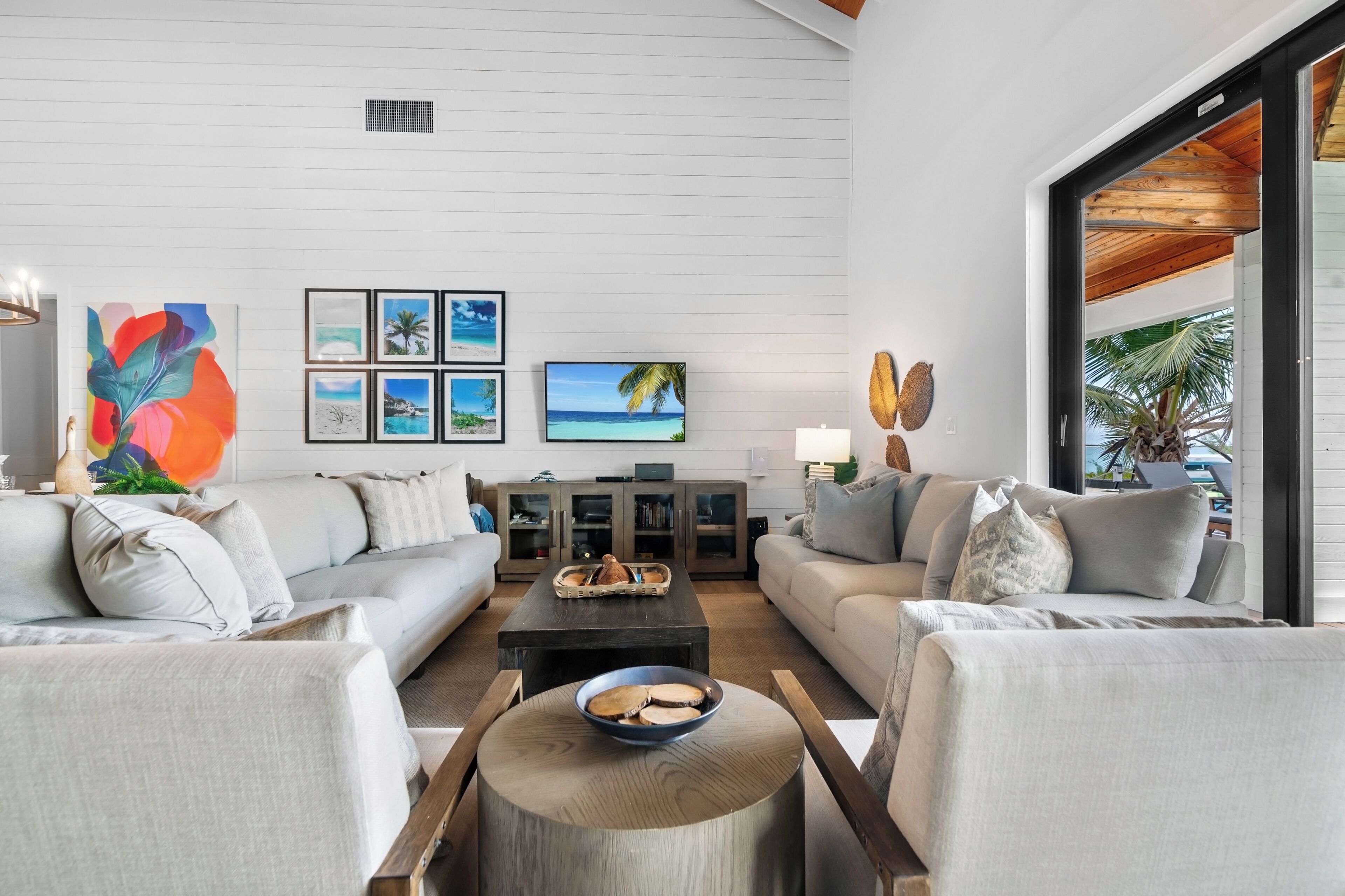 A modern living room with a sofa set, a coffee table, and artwork on the wall.