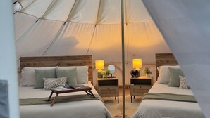 A tented accommodation with two beds, each with a nightstand, lamps, and decorative items. - Secret Sycamore– Private Stargazing Glamping Tent with Fire Pit & Open Skies (Bunker)