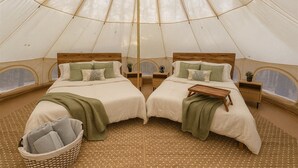 A tent with two beds, each with a wooden headboard, a small bedside table, and a green throw blanket. - Secret Sycamore– Private Stargazing Glamping Tent with Fire Pit & Open Skies (Bunker)