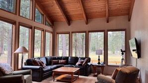 A spacious living room with a large sectional sofa, a coffee table, and a television mounted on the wall. - Black Butte Ranch `Trip House` On the Golf Course (Sisters)