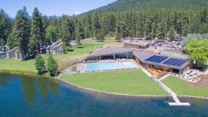 A resort with a swimming pool, solar panels, and a dock extending into a lake. - Black Butte Ranch `Trip House` On the Golf Course (Sisters)