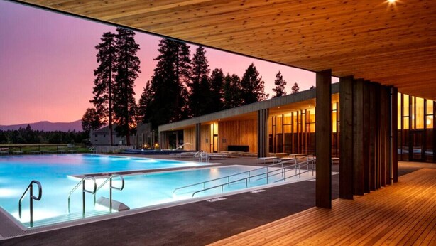 A modern building with a pool, wooden deck, and large windows. - Black Butte Ranch `Trip House` On the Golf Course (Sisters)
