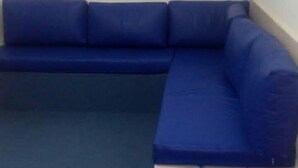 Un sofà blau modular col·locat en una cantonada d'una habitació.