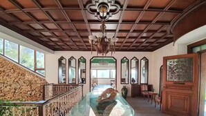 Un vestíbulo amplio con una mesa de cristal, una escalera y un candelabro.
