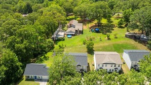 A residential area with multiple houses, a swimming pool, and a well-maintained lawn.