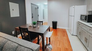 A modern kitchen with a microwave, refrigerator, and wooden flooring. - 2 King Beds / 55" TV / Rainfall Shower / W/D (Philadelphia)