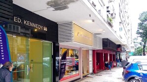 A street view with storefronts, including a visible address "ED. KENNEDY 98". - Kitnet Apartment Copacabana (Copacabana Rio de Janeiro)