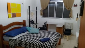 A bedroom with a bed, a desk, a chair, a wardrobe, and a window with curtains. - Kitnet Apartment Copacabana (Copacabana Rio de Janeiro)