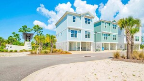 A two-story beachfront house with a covered driveway and a sandy beach in front. - Sunny Gulf Getaway 3bed/4bath, pool, walk to beach (Orange Beach)