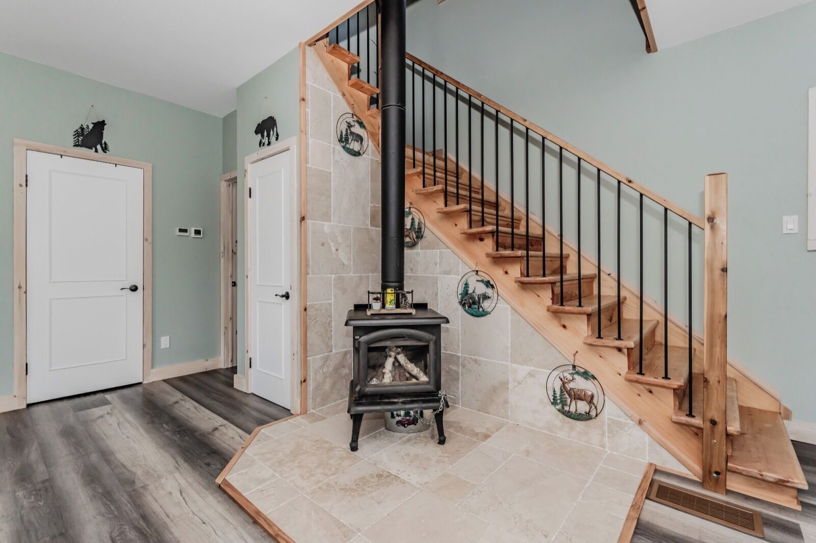 A staircase with wooden steps and black railings, leading to a room with a fireplace.