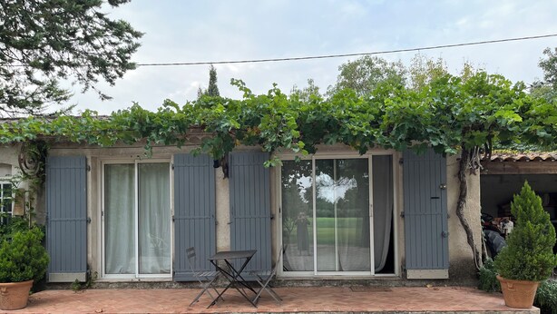 A house with a gravel driveway, a small table, and potted plants. - Studio in the countryside near village with all amenities (Sénas)