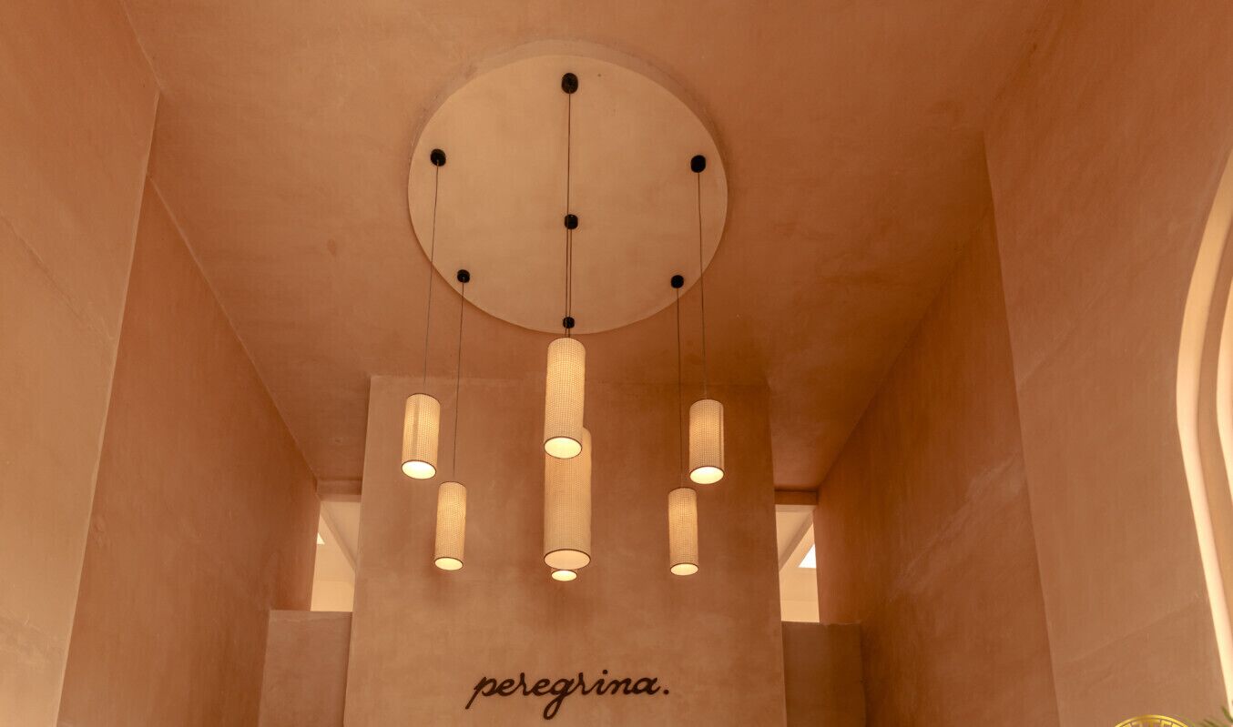 Un techo con una lámpara circular y cuatro luces cilíndricas colgantes.